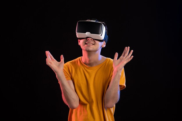 Portrait de jeune homme portant un casque vr sur le mur sombre