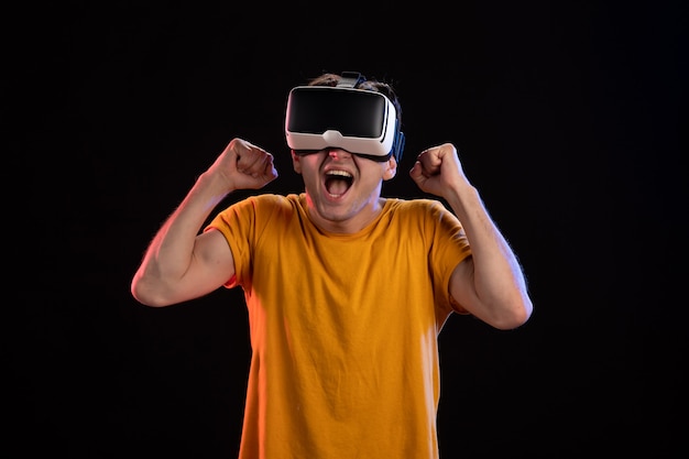 Portrait de jeune homme portant un casque vr sur le mur sombre