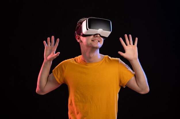 Portrait de jeune homme portant un casque vr sur le mur sombre