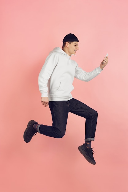 Portrait de jeune homme de race blanche avec des émotions vives sur fond de studio rose