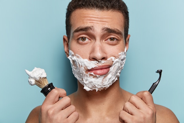 Portrait de jeune homme se raser la barbe