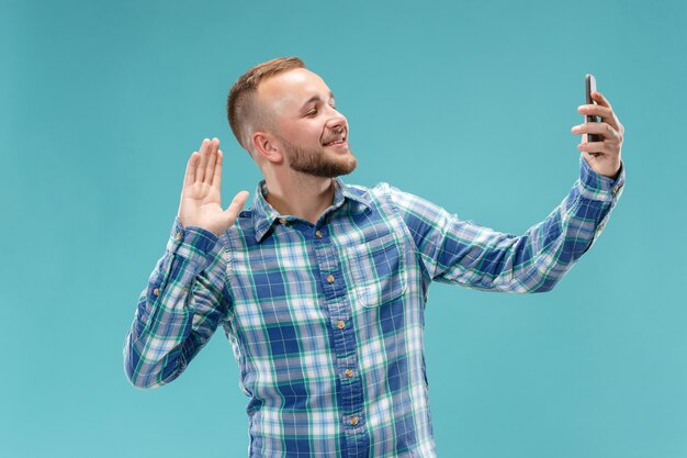 Portrait de jeune homme séduisant prenant un selfie avec son smartphone