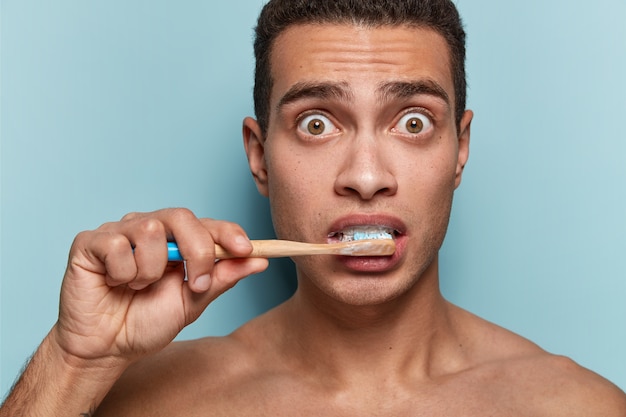 Portrait de jeune homme tenant une brosse à dents