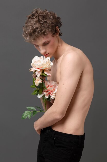 Portrait jeune homme tenant des fleurs