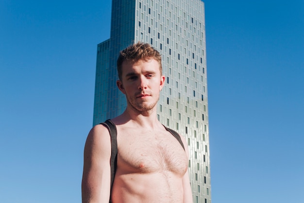 Portrait de jeune homme torse nu, regardant la caméra