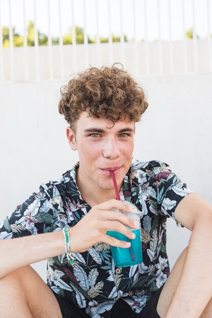 Portrait d&#39;un jeune homme en train de boire du jus