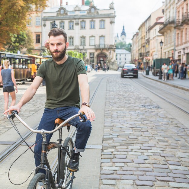 Portrait d&#39;un jeune homme en vélo dans la ville