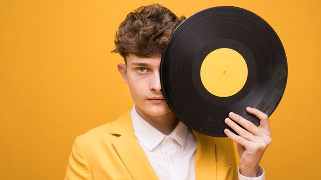 Portrait de jeune homme avec un vinyle dans une scène jaune