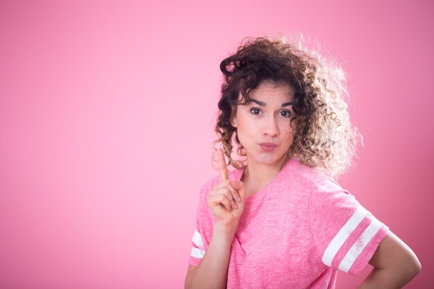 Portrait de jeune jolie fille surprise aux cheveux bouclés