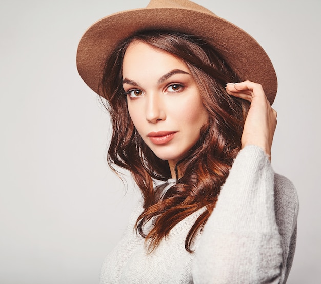 Portrait de jeune mannequin élégant en vêtements d'été gris décontracté en chapeau brun avec maquillage naturel