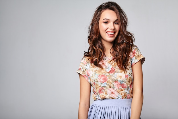 Portrait de jeune mannequin rire élégant dans des vêtements d'été décontractés colorés avec du maquillage naturel