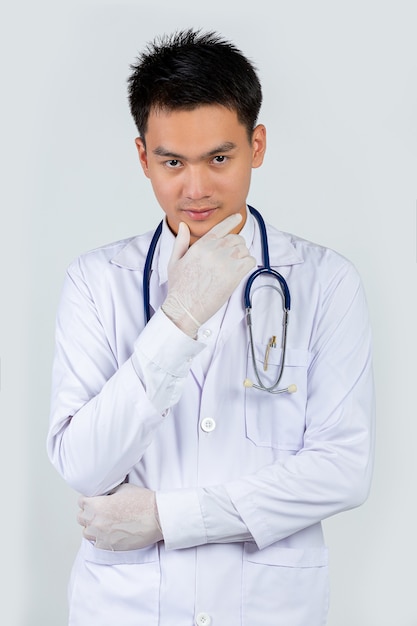 Photo gratuite portrait de jeune médecin confiant sur mur blanc.