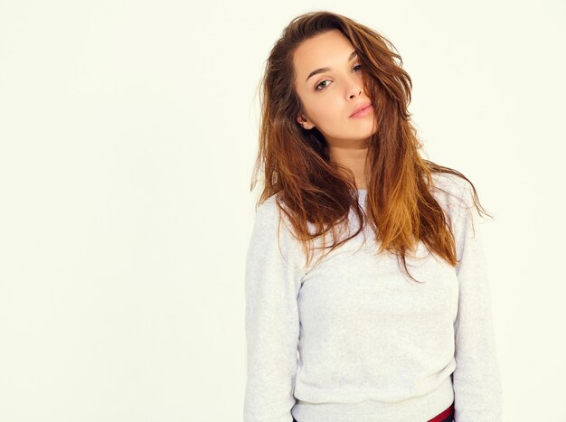 Portrait de jeune modèle mignon femme élégante en costume de sport gris décontracté avec maquillage naturel isolé sur mur blanc