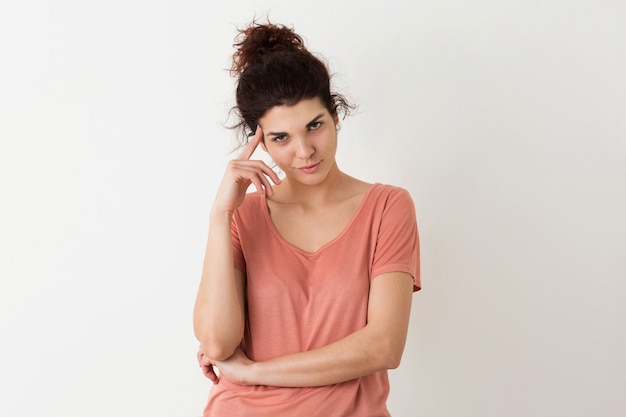 Portrait de jeune naturel à la recherche de sourire heureux hipster jolie femme en chemise rose posant isolé, pensant et ayant un problème