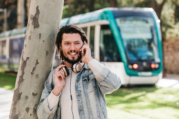 Portrait, jeune, sourire, conversation, téléphone portable, contre, flou, autobus