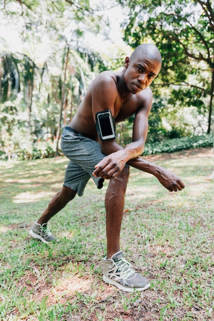 Portrait d&#39;un jeune sportif au parc faisant des exercices d&#39;étirement