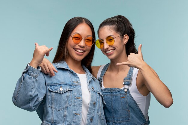 Portrait de jeunes adolescentes avec des lunettes de soleil montrant l'indicatif d'appel