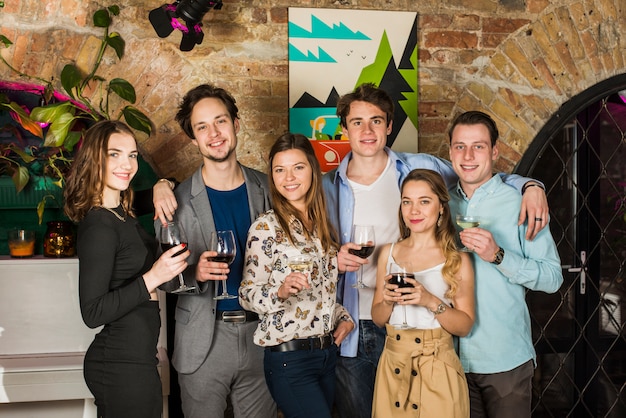 Portrait de jeunes amis tenant des verres de boissons en boîte de nuit