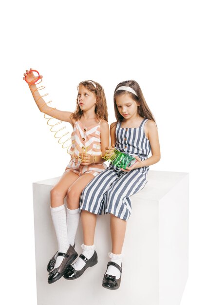 Portrait de jeunes petites filles enfants jouant ensemble s'amusant isolé sur fond blanc studio