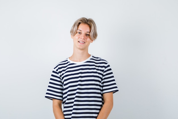 Portrait de joli garçon adolescent posant en t-shirt rayé et à la vue de face joyeuse