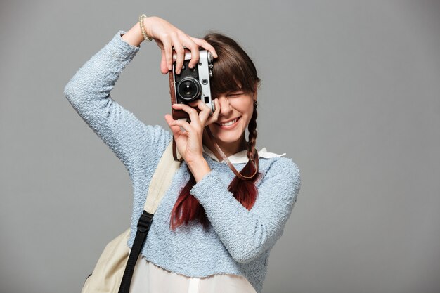 Portrait d'une jolie écolière souriante prenant une photo