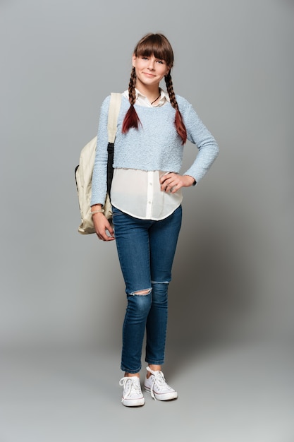 Portrait d'une jolie écolière souriante avec sac à dos