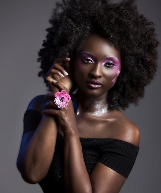 Photo gratuite portrait d'une jolie femme afro-américaine avec un beau maquillage portant une bague fleur