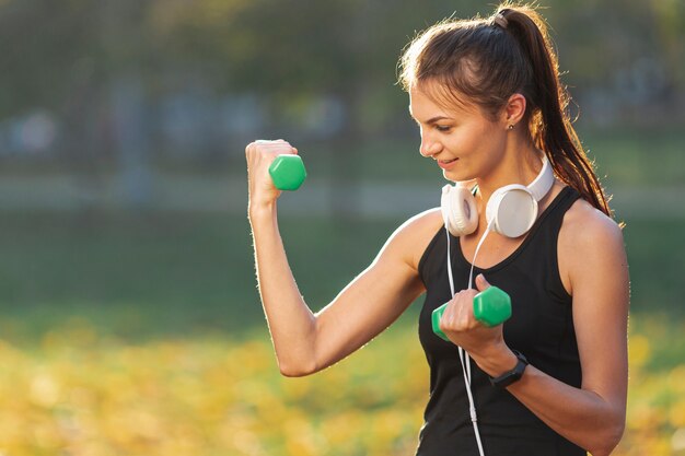 Portrait de jolie femme à l'aide de poids de fitness