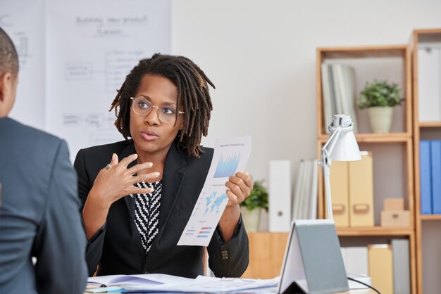 Portrait de jolie femme cubaine présentant les informations statistiques à son patron méconnaissable