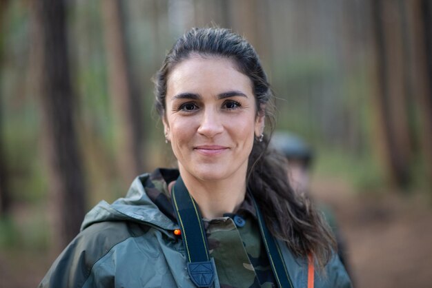 Portrait de jolie femme en forêt. Modèle féminin aux cheveux noirs et queue de cheval regardant la caméra. Portrait, notion de beauté