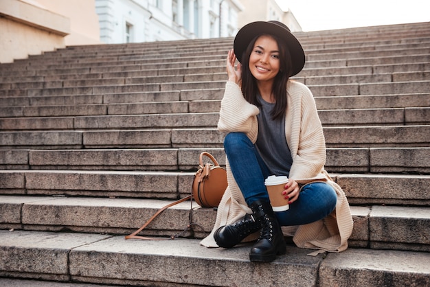 Portrait d'une jolie femme heureuse tenant une tasse de café