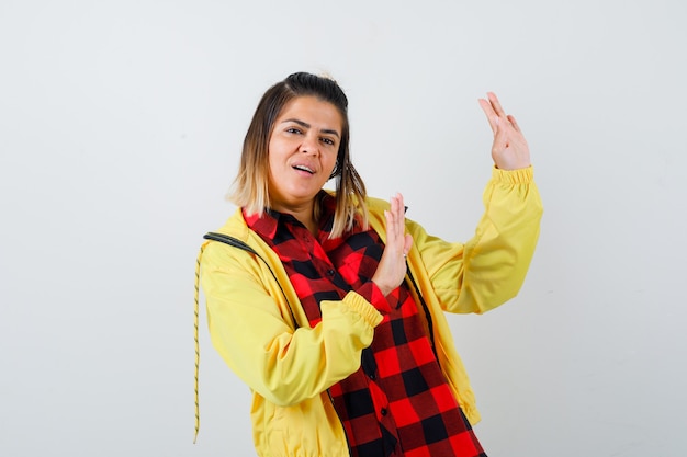 Portrait de jolie femme montrant un geste d'arrêt en chemise, veste et à la vue de face honteuse