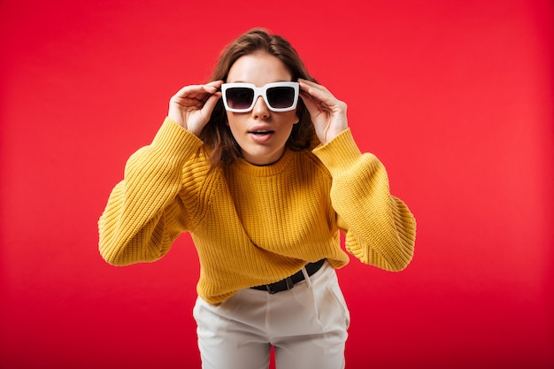 Portrait d'une jolie femme en posant des lunettes de soleil