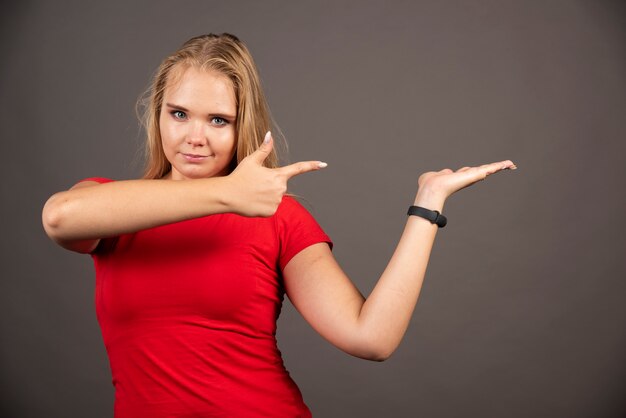 Portrait de jolie femme posant sur un mur sombre.