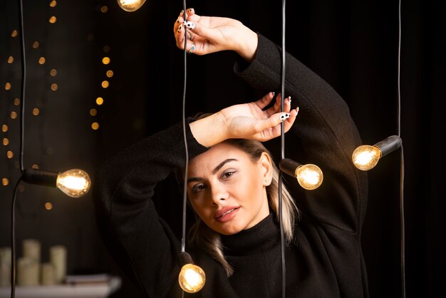 Portrait de jolie femme en pull noir debout et posant