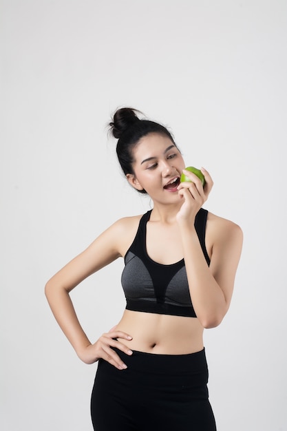 Portrait de jolie femme souriante tenant avec apple isolé sur fond blanc.