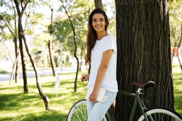 Portrait d'une jolie femme souriante tenant un livre