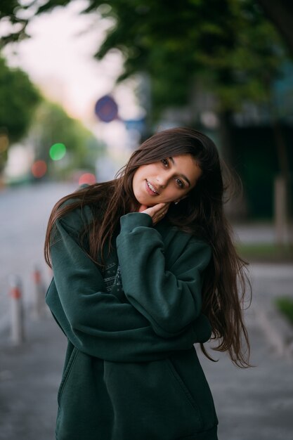 Portrait de jolie fille aux cheveux longs regarde la caméra