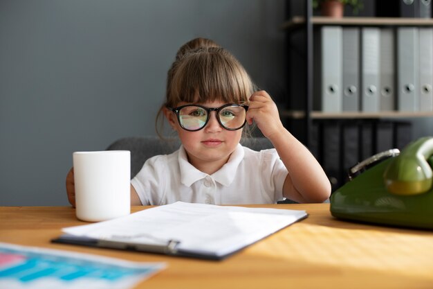 Portrait de jolie fille avec des lunettes travaillant au bureau