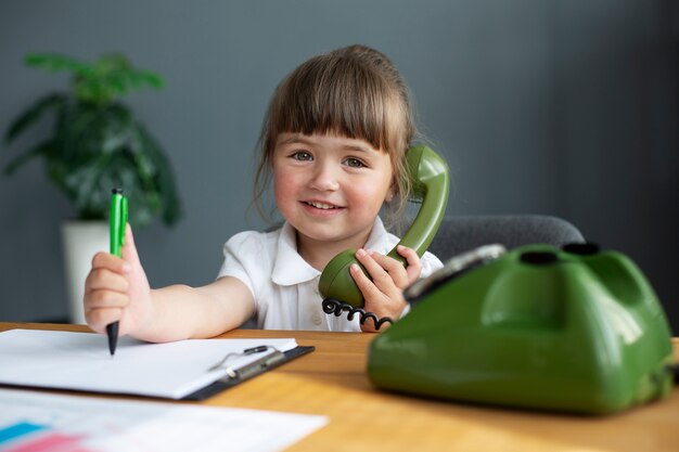 Portrait de jolie fille parlant au téléphone à cadran au bureau