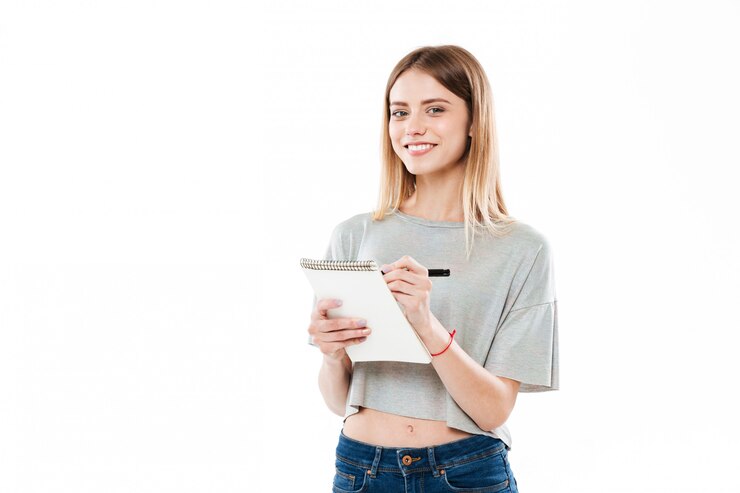 Photo gratuit portrait d'une jolie fille prenant des notes dans un bloc-notes