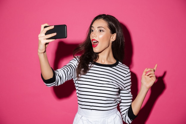 Portrait d'une jolie fille prenant un selfie