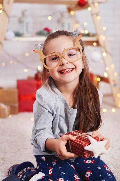 Portrait de jolie fille tenant un cadeau de Noël