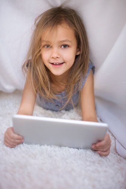 Portrait de jolie fille tenant une tablette numérique