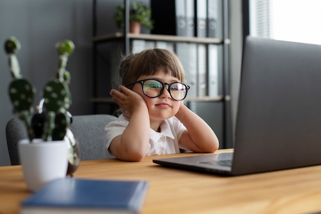 Portrait de jolie fille travaillant au bureau sur un ordinateur portable