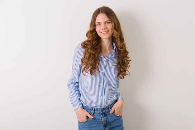 Portrait de jolie jeune femme bouclée aux cheveux longs bouclés blonds