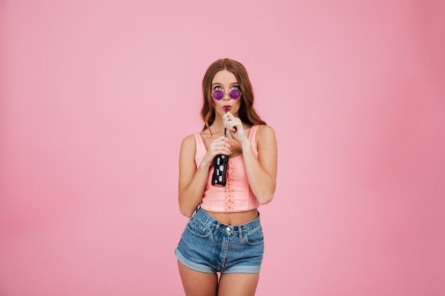 Portrait d'une jolie jeune femme à lunettes de soleil