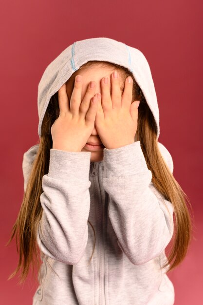 Portrait de jolie jeune fille couvrant les yeux