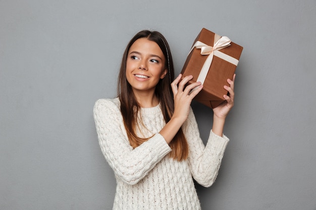 Portrait D'une Jolie Jeune Fille En Pull Holding Present