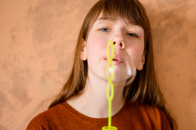 Portrait de jolie jeune fille soufflant des bulles